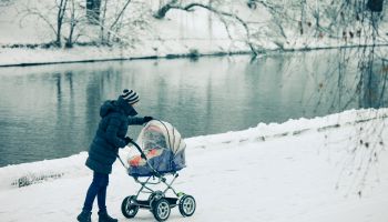Woman with a baby stroller on a walk in the park