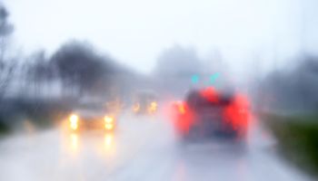 Blurry traffic scene through windshield during heavy afternoon rain in Florida