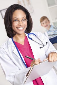 Happy Doctor Writing Something With Young Patient Behind Her