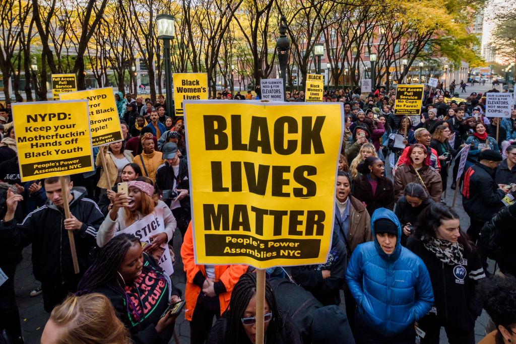 Participants holding BLACK LIVES MATTER protest signs at the...