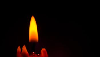 Lighted Candle with Black Background.