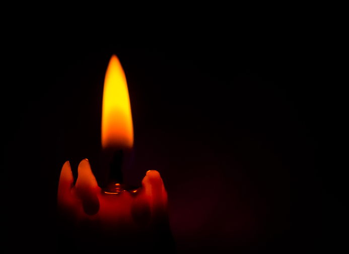 Lighted Candle with Black Background.