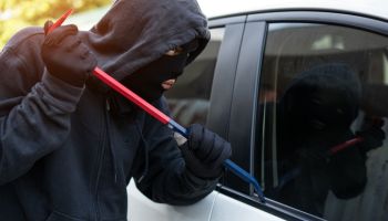 Car theft - thief trying to break into the vehicle.