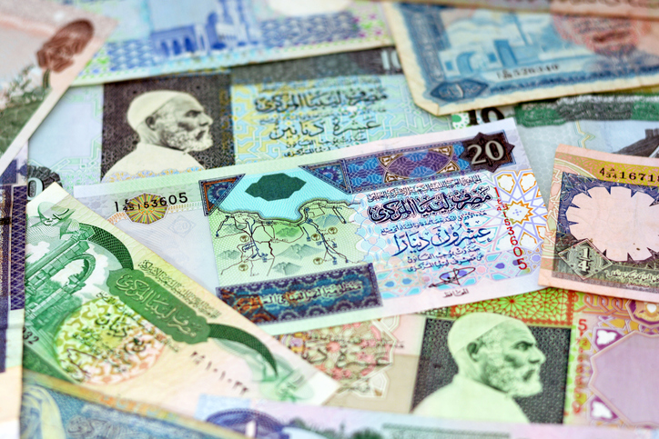 Background of Libyan money dinars banknotes with portraits of Omar Al-Mukhtar and Muammar Gaddafi on some banknotes, selective focus of different banknotes from Libya of different values and years