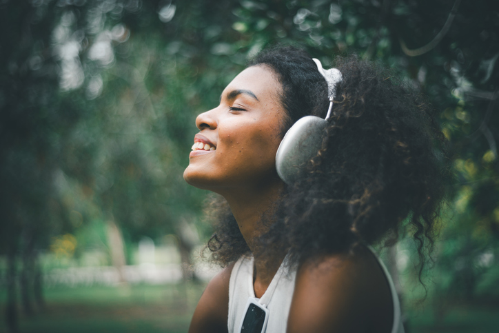 Cheerful woman listening to music with a mobile outdoors